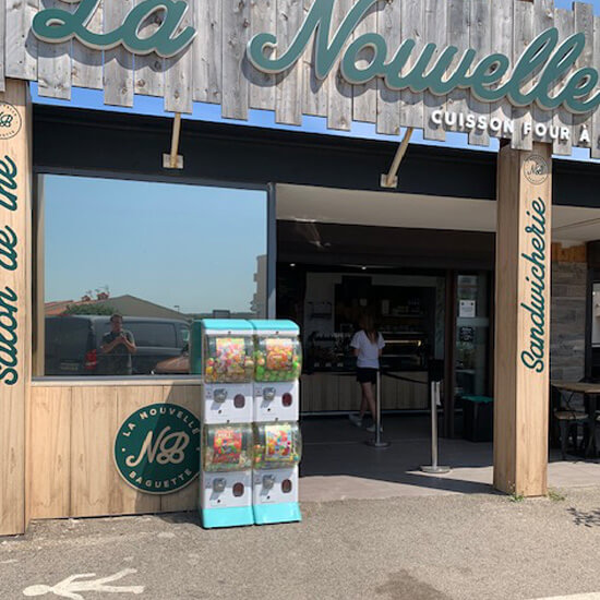 Distributeurs de capsules et de jouets devant une boulangerie